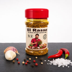 El Rasso Gewürzdose mit Chili, Knoblauch, Pfefferkörnern und Salz auf dunkler Fläche.