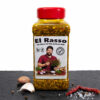 El Rasso Gewürzbehälter auf dunkler Fläche, umgeben von Chili, Knoblauch, Pfefferkörnern und grobem Salz.