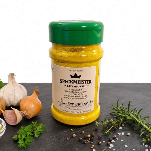 Speckmeister Gewürzdose umgeben von frischen Kräutern, Knoblauch, Zwiebeln und Gewürzen – Schweizer Qualitätsprodukt
