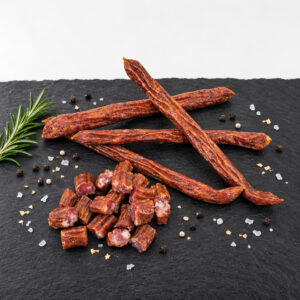 Buure-Chrampfer - geschnitten Buure-Chrampfer Rohwurst ganz und in Stücke geschnitten auf Schieferplatte mit Rosmarin, Pfeffer und Meersalz