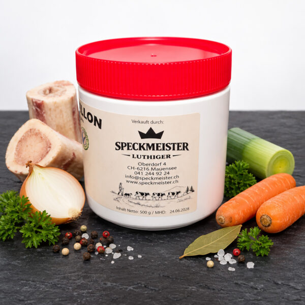 Ochsenbouillon 500 g in Dose mit rotem Deckel, Seitenansicht mit Speckmeister Luthiger Etikette, auf Schieferplatte mit Markknochen, Zwiebel, Lauch, Karotten, Lorbeer, Petersilie, Pfeffer und Meersalz